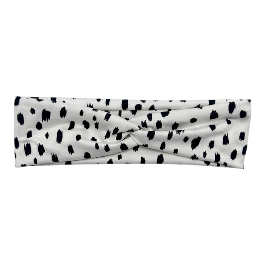 White headband with black polka dot pattern on a white background