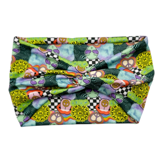 Colorful fabric with patterns including peace signs and checkered designs on a white background